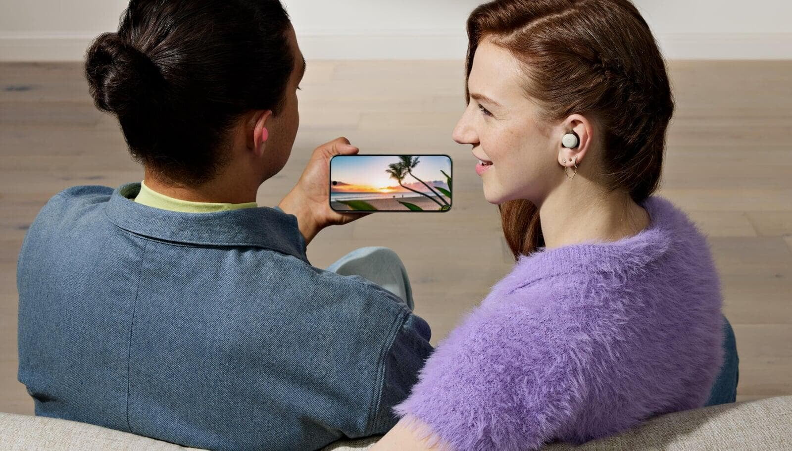 Woman and man looking a video in Google Pixel with Google Buds omn 