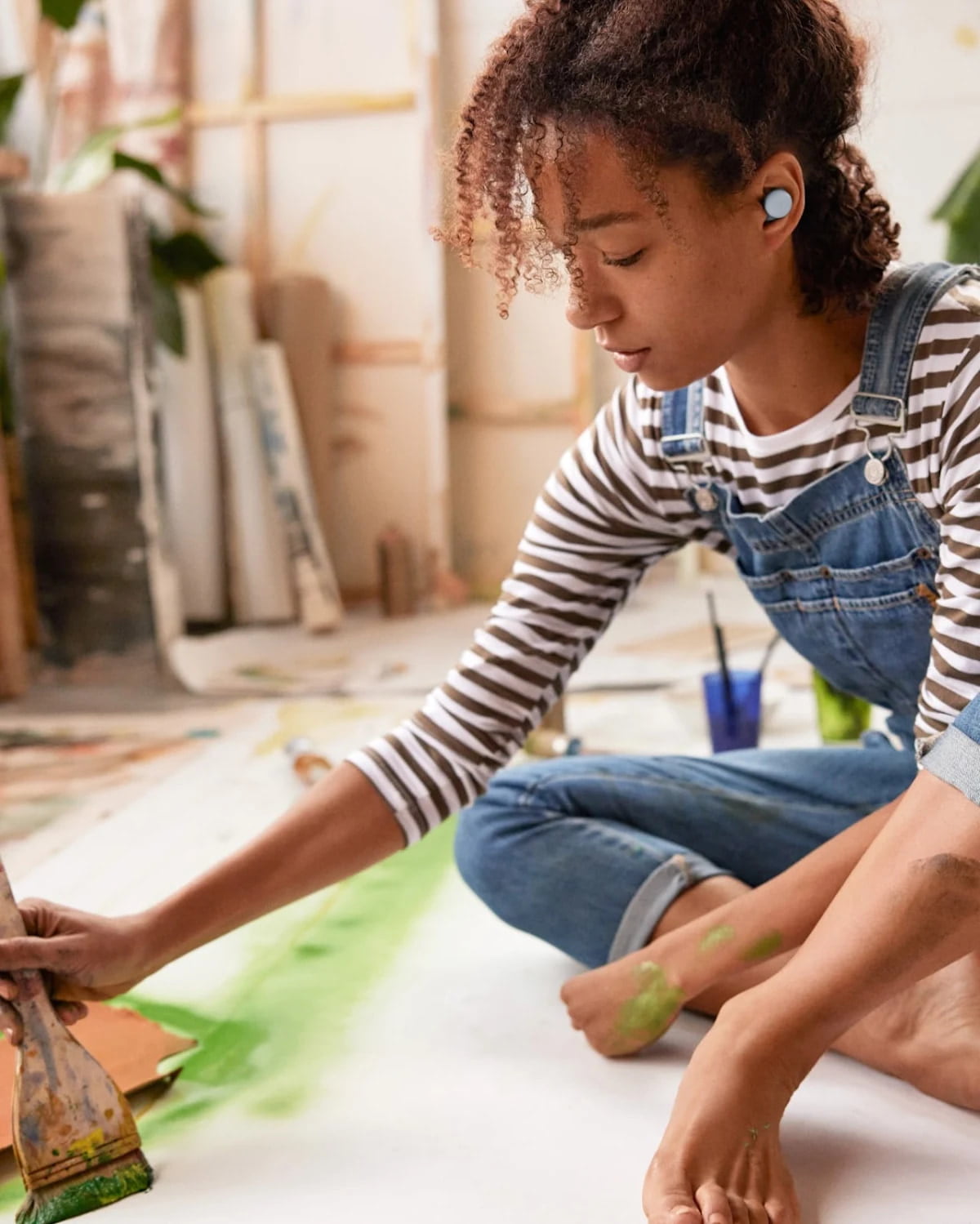 Chica pintando escuchando musica en los Google Buds Pro